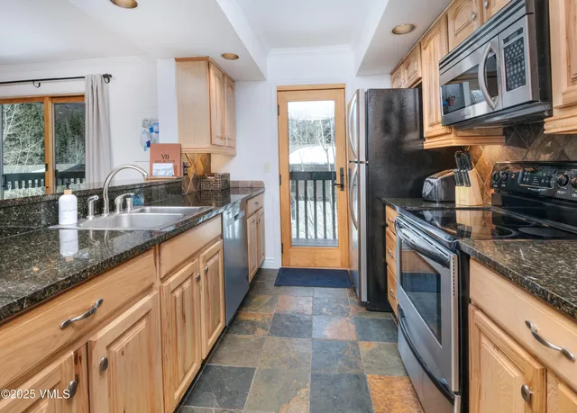 a kitchen with granite countertop a sink stove and cabinets