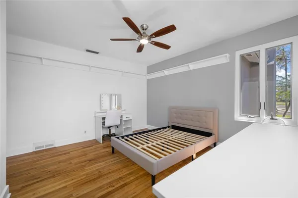 a view of empty room with wooden floor and fan