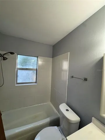 a white toilet sitting next to a bath tub