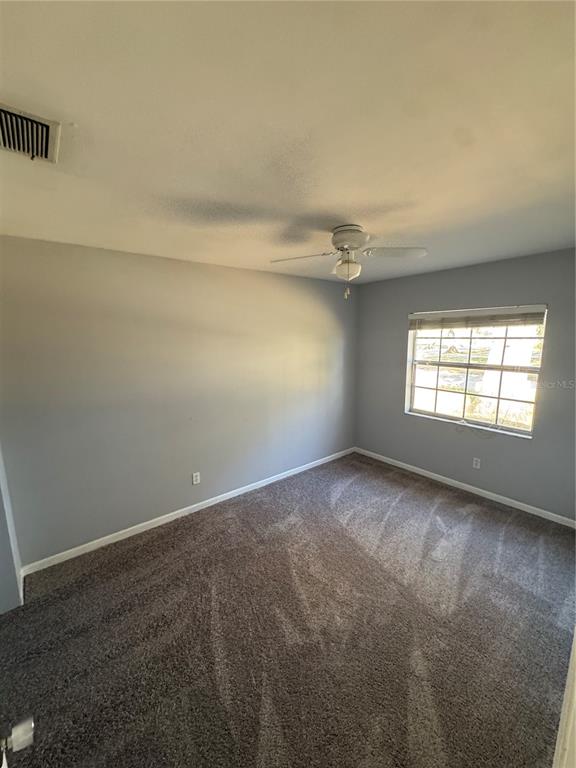 301 Hickory Lane Seffner, FL 33584 - Photo 9 of 14 an empty room with windows and chandelier fan