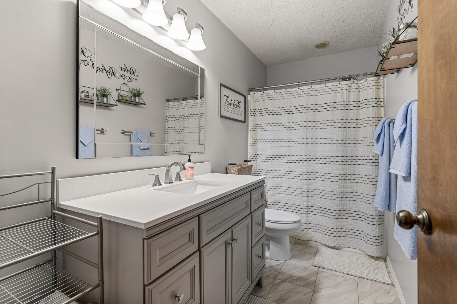 2717 East Main Street Decatur, IL 62521 - Photo 19 of 31 a bathroom with a sink a toilet and shower curtain