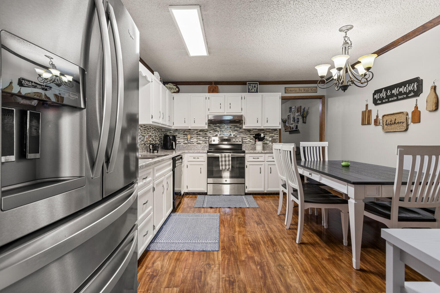 2717 East Main Street Decatur, IL 62521 - Photo 8 of 31 a kitchen with stainless steel appliances granite countertop a refrigerator a stove oven a sink dishwasher and white cabinets with wooden floor