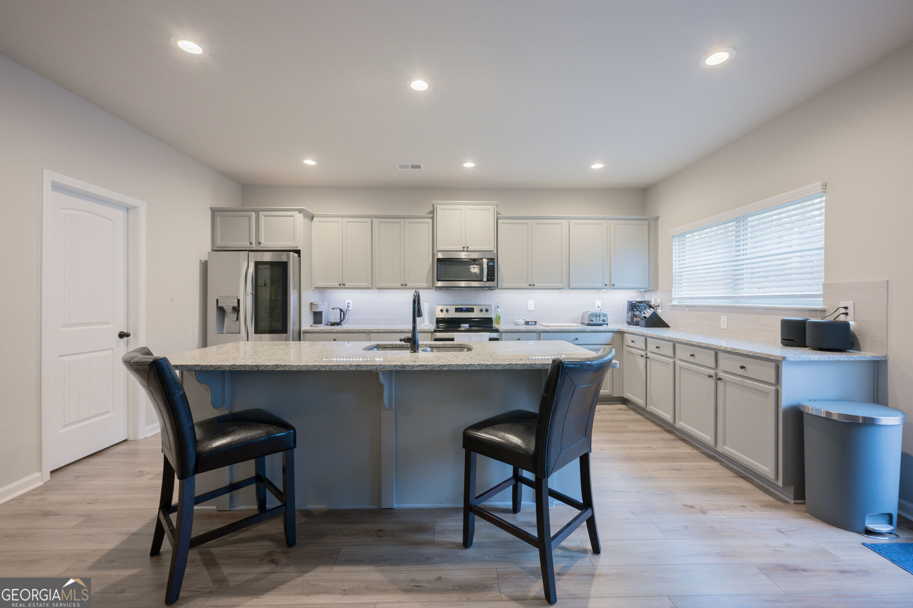 10155 Cormac Street Jonesboro, GA 30238 - Photo 11 of 40 a kitchen with a table chairs microwave and cabinets