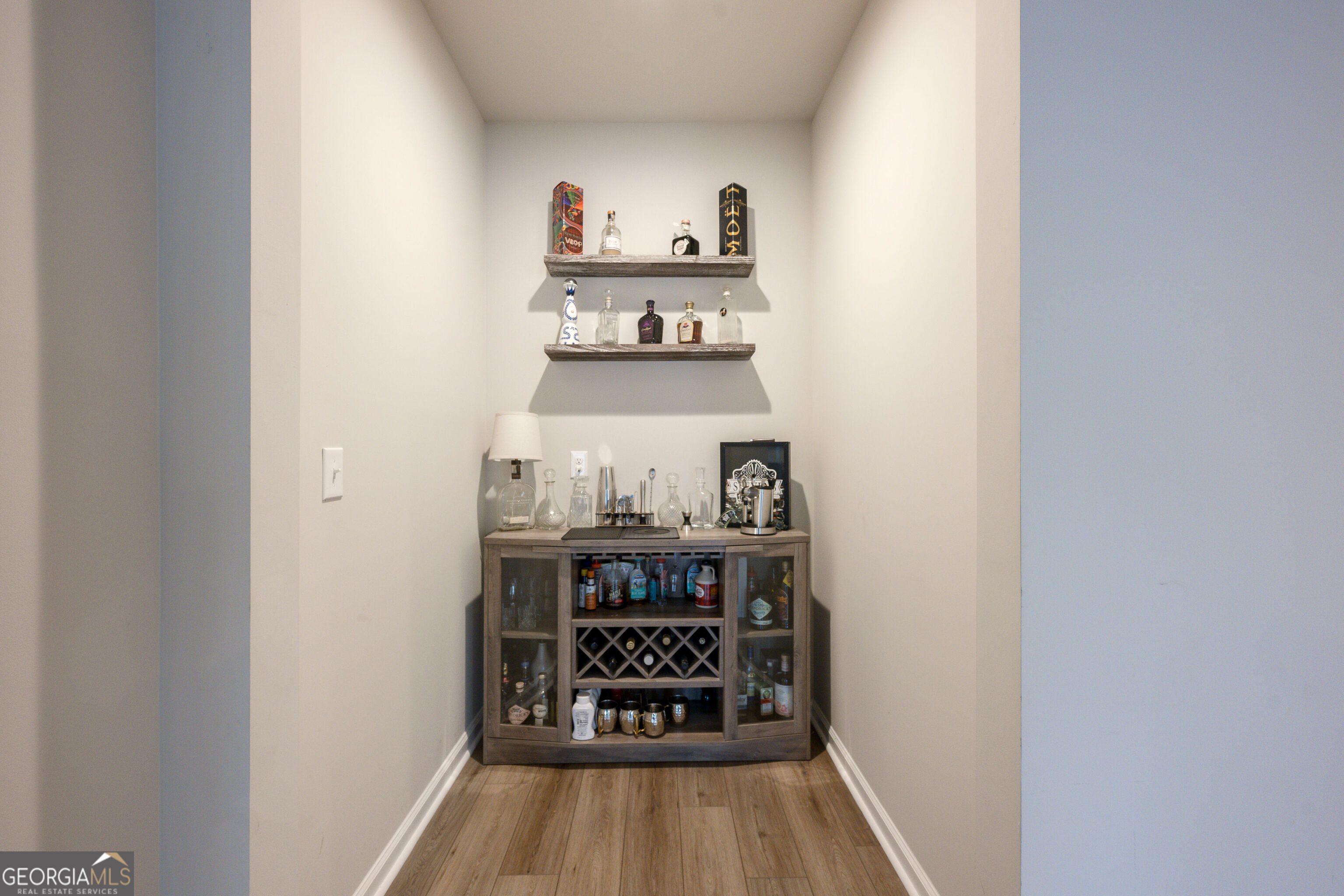 10155 Cormac Street Jonesboro, GA 30238 - Photo 14 of 40 a view of a hallway with wooden floor and a white cabinet