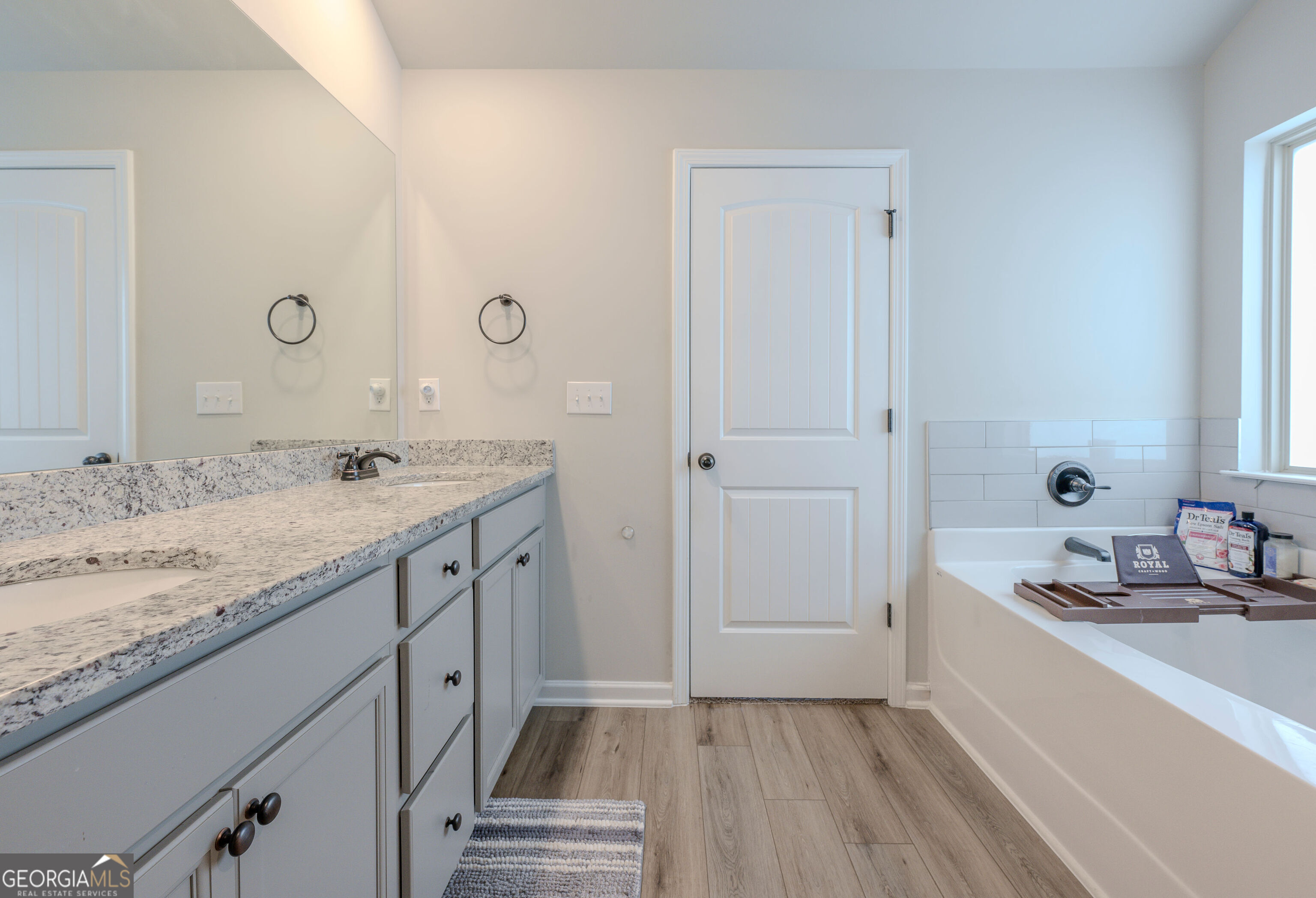 10155 Cormac Street Jonesboro, GA 30238 - Photo 30 of 40 a spacious bathroom with a granite countertop sink mirror and a bathtub