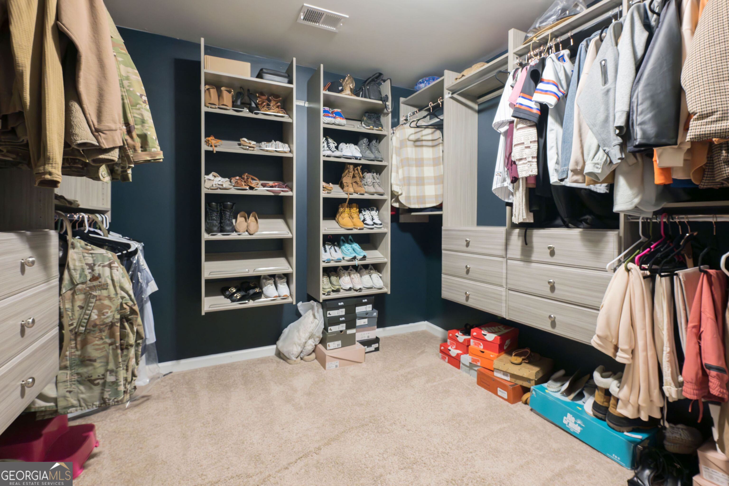 10155 Cormac Street Jonesboro, GA 30238 - Photo 31 of 40 a view of walk in closet with clothes and shoes