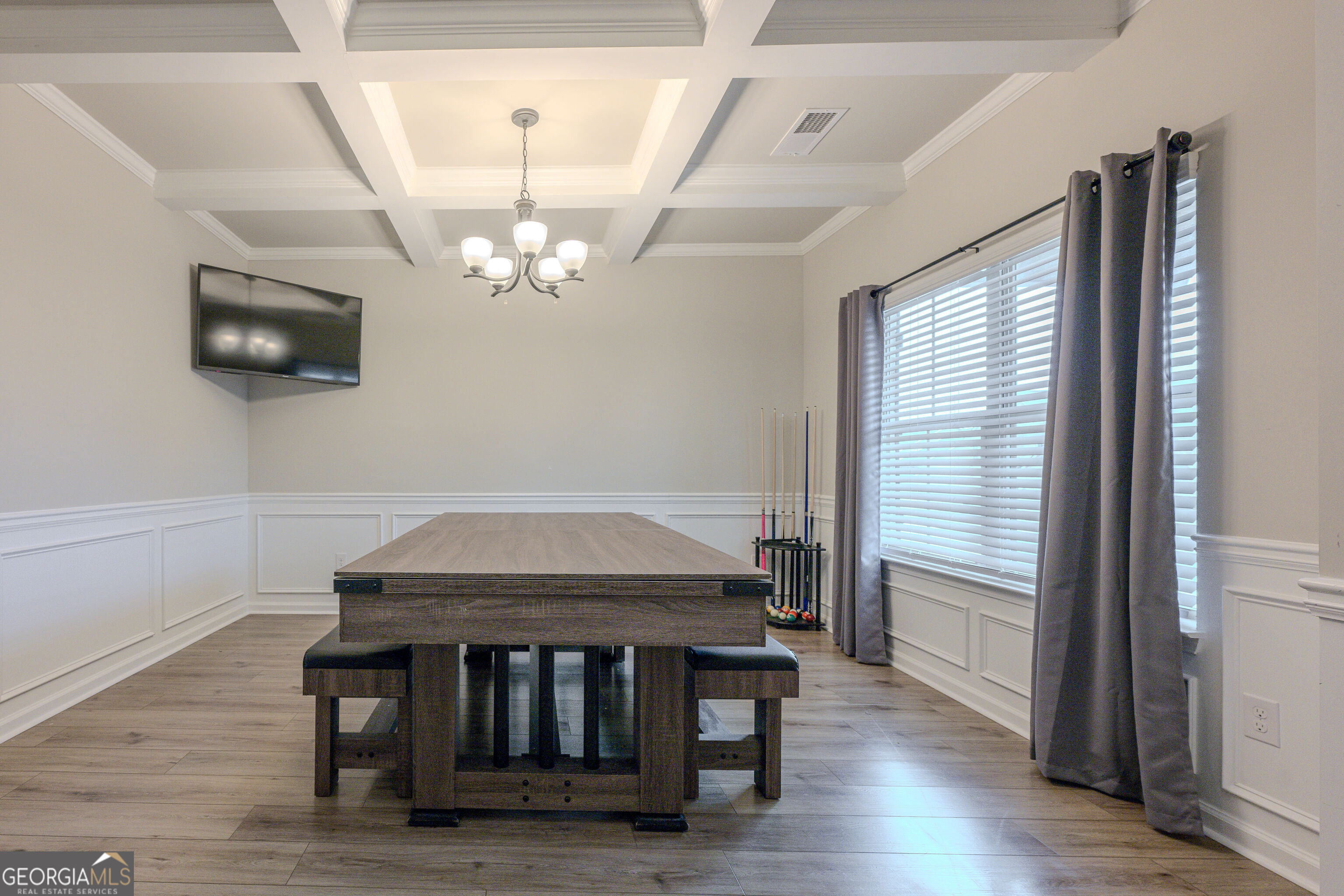 10155 Cormac Street Jonesboro, GA 30238 - Photo 5 of 40 a dining room with wooden floor a chandelier a wooden table and chairs