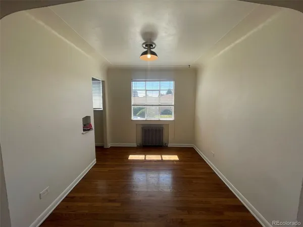 a view of empty room with wooden floor