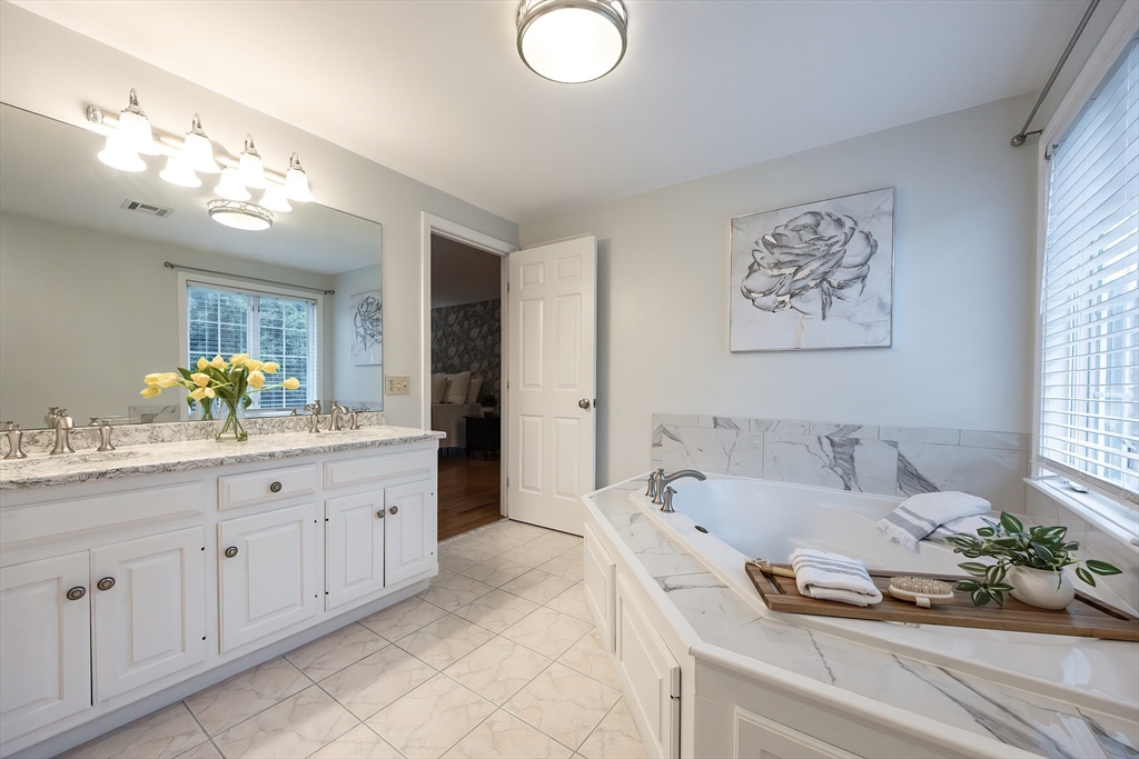 85 Sheldonville Road North Attleboro, MA 02760 - Photo 28 of 42 a spacious bathroom with a granite countertop sink a large mirror and a bathtub