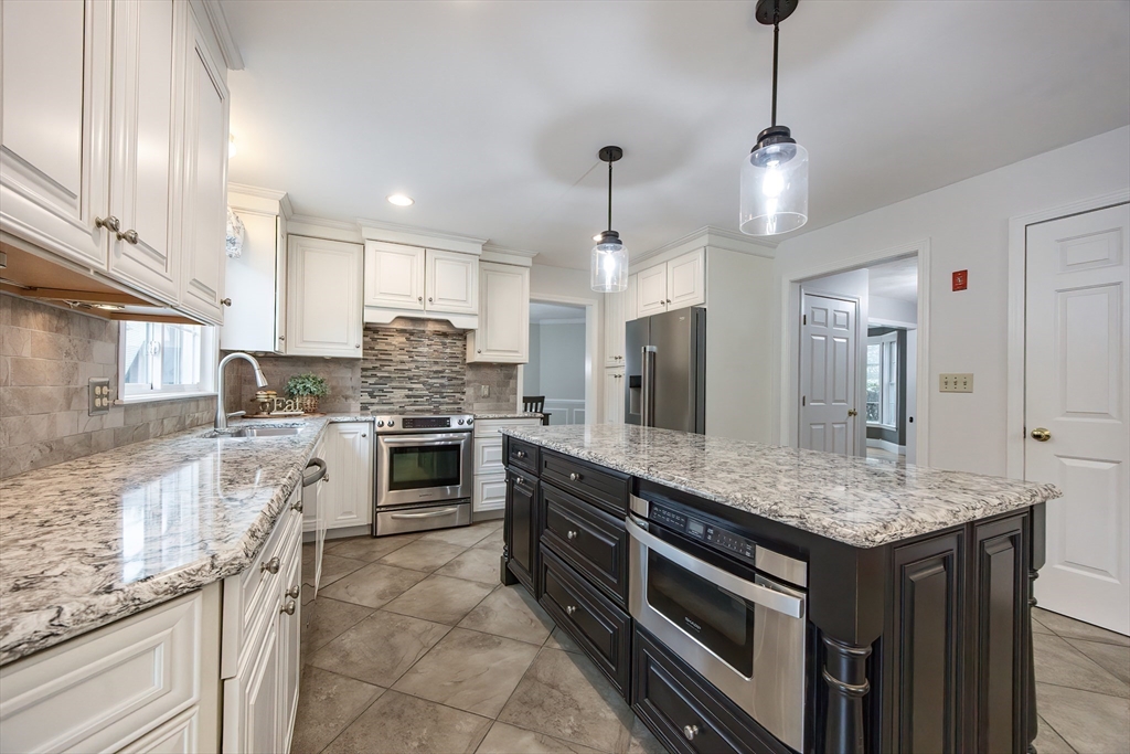 85 Sheldonville Road North Attleboro, MA 02760 - Photo 6 of 42 a kitchen with stainless steel appliances granite countertop a stove top oven a sink refrigerator and cabinets