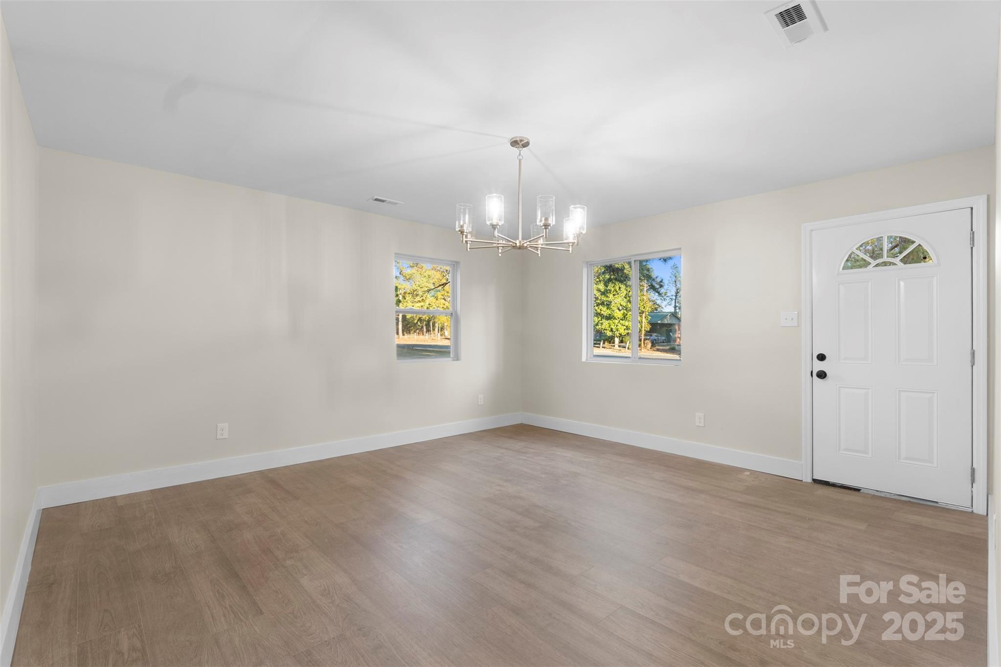 15861 Palmer Road Marston, NC 28363 - Photo 5 of 28 an empty room with a window and a chandelier