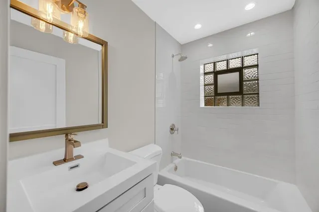 a bathroom with a sink a toilet and mirror