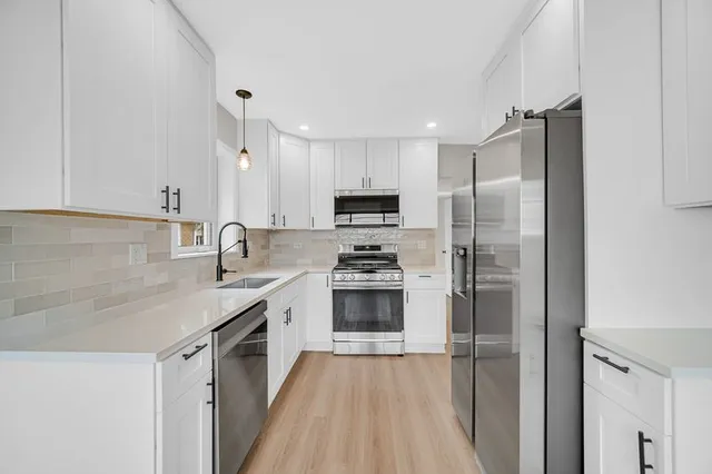 a kitchen with stainless steel appliances granite countertop a sink stove a microwave and cabinets