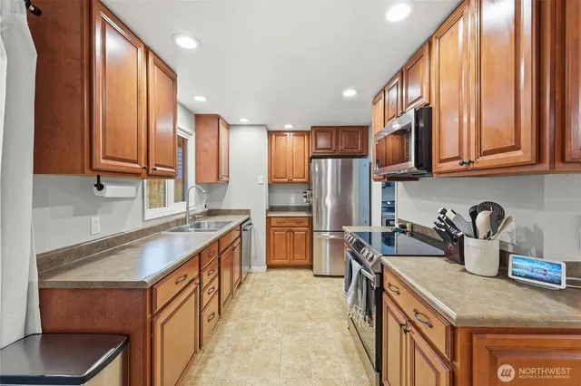 a kitchen with stainless steel appliances granite countertop a sink stove and refrigerator