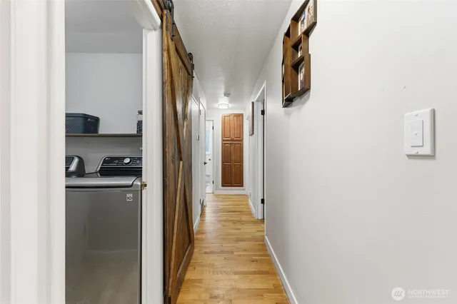 a view of a hallway with wooden floor and staircase