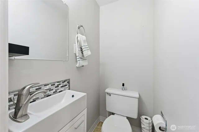 a bathroom with a sink a toilet and mirror