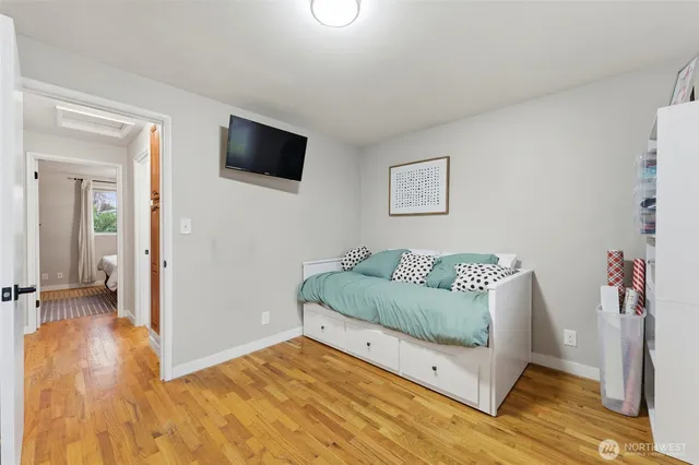 a living room with a bed and a flat screen tv