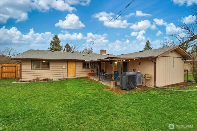 a view of a house with backyard and sitting area