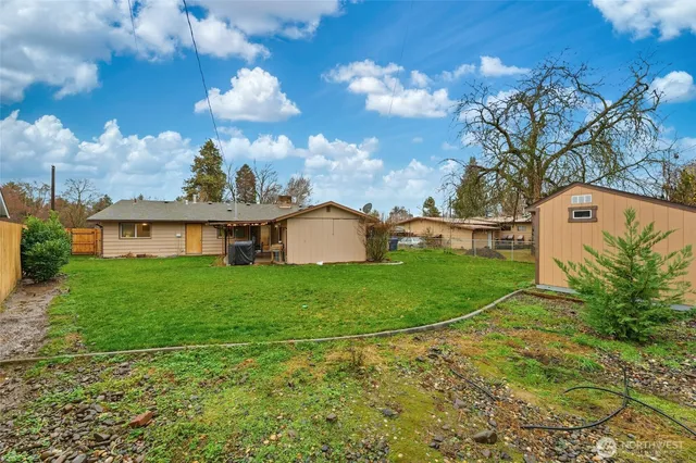 a view of a big house with a big yard and potted plants