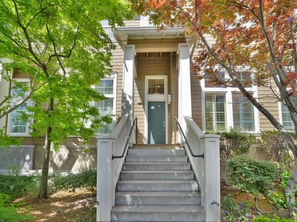 a view of a house with large windows and a tree