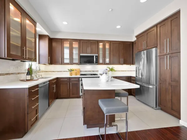 a kitchen with a refrigerator a sink dishwasher and a stove with wooden floor