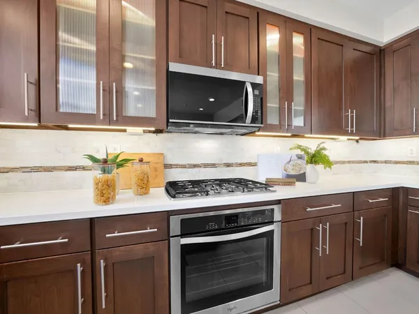 a kitchen with granite countertop a stove microwave and sink