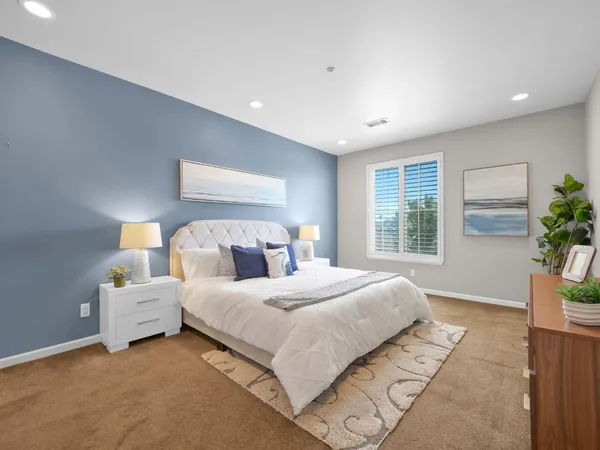 a bedroom with a large bed and a potted plant