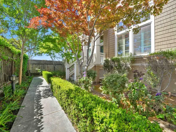 a front view of a house with a yard and potted plants