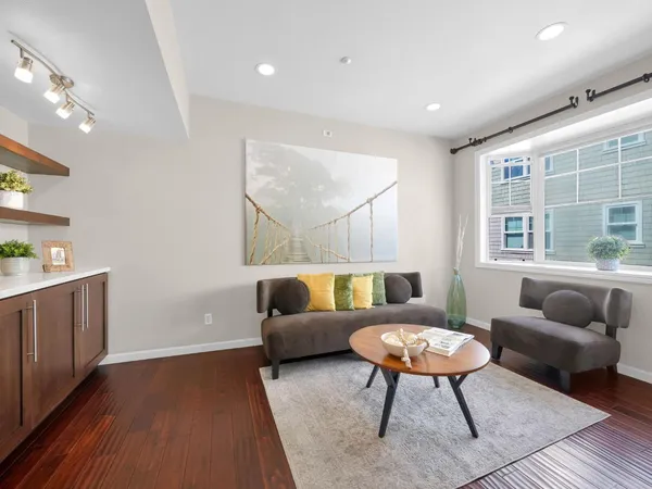 a living room with furniture and a wooden floor
