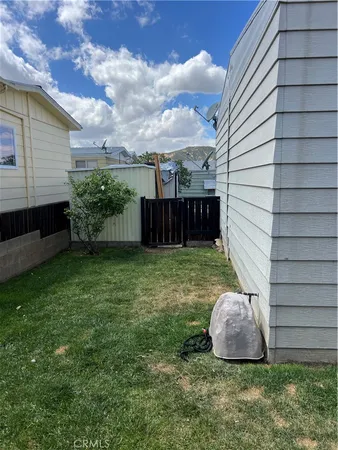 a view of a backyard with potted plants and wooden fence