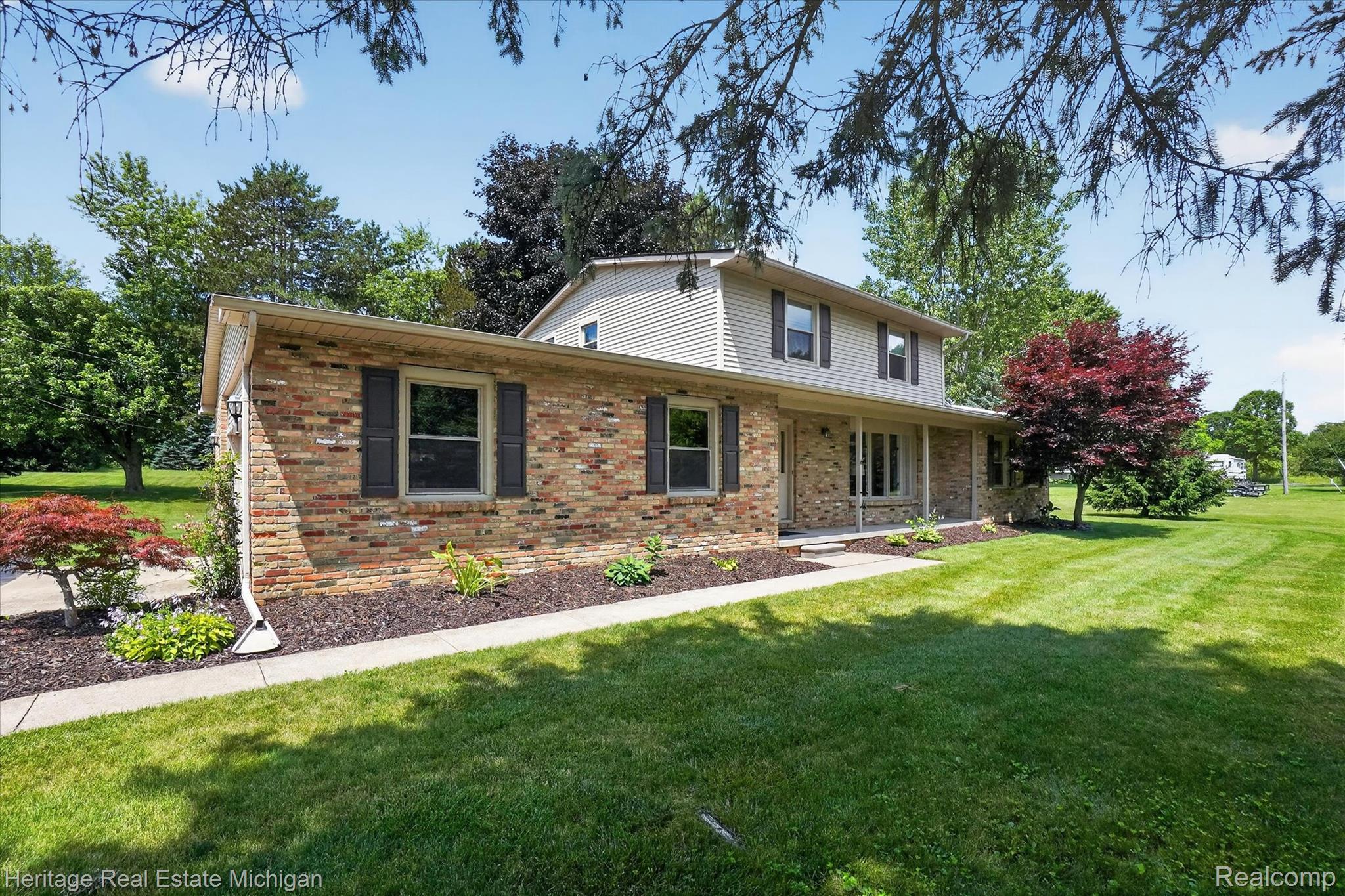 14038 North Hogan Road Linden, MI 48451 - Photo 51 of 53 Brick and siding exterior with dark shutters and a covered front porch