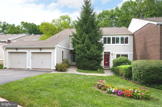 a view of a white house with a big yard and potted plants