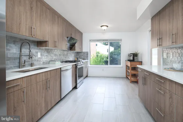 a large kitchen with stainless steel appliances granite countertop a stove a sink dishwasher and a oven