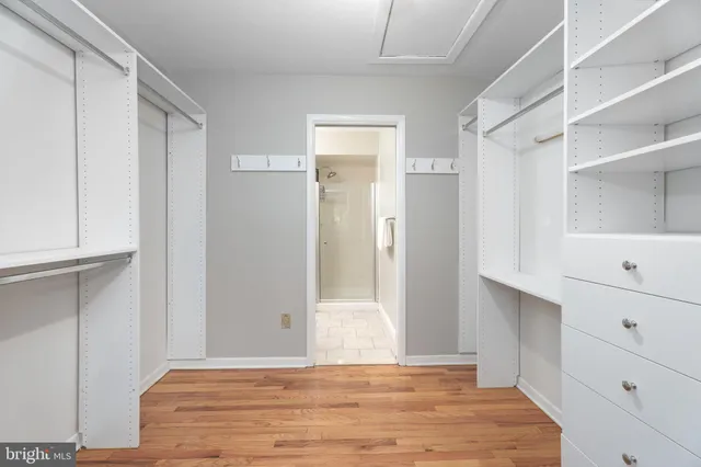 a view of an empty room with cabinet and wooden floor