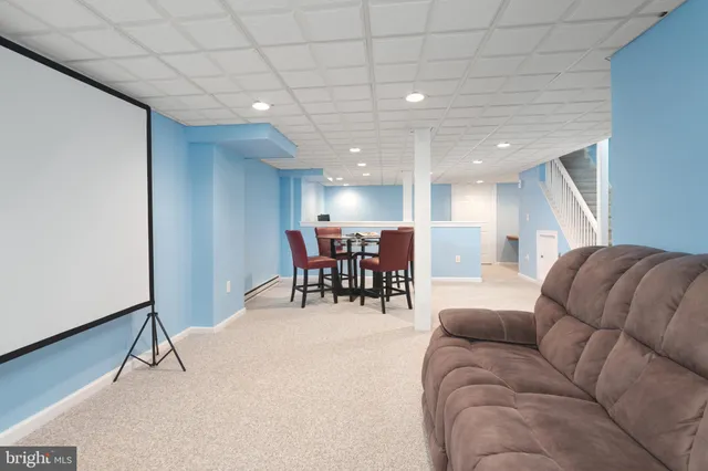a living room with furniture and kitchen view with a large window