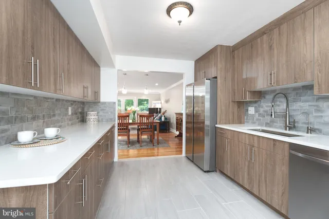 a kitchen with stainless steel appliances granite countertop a sink refrigerator and cabinets