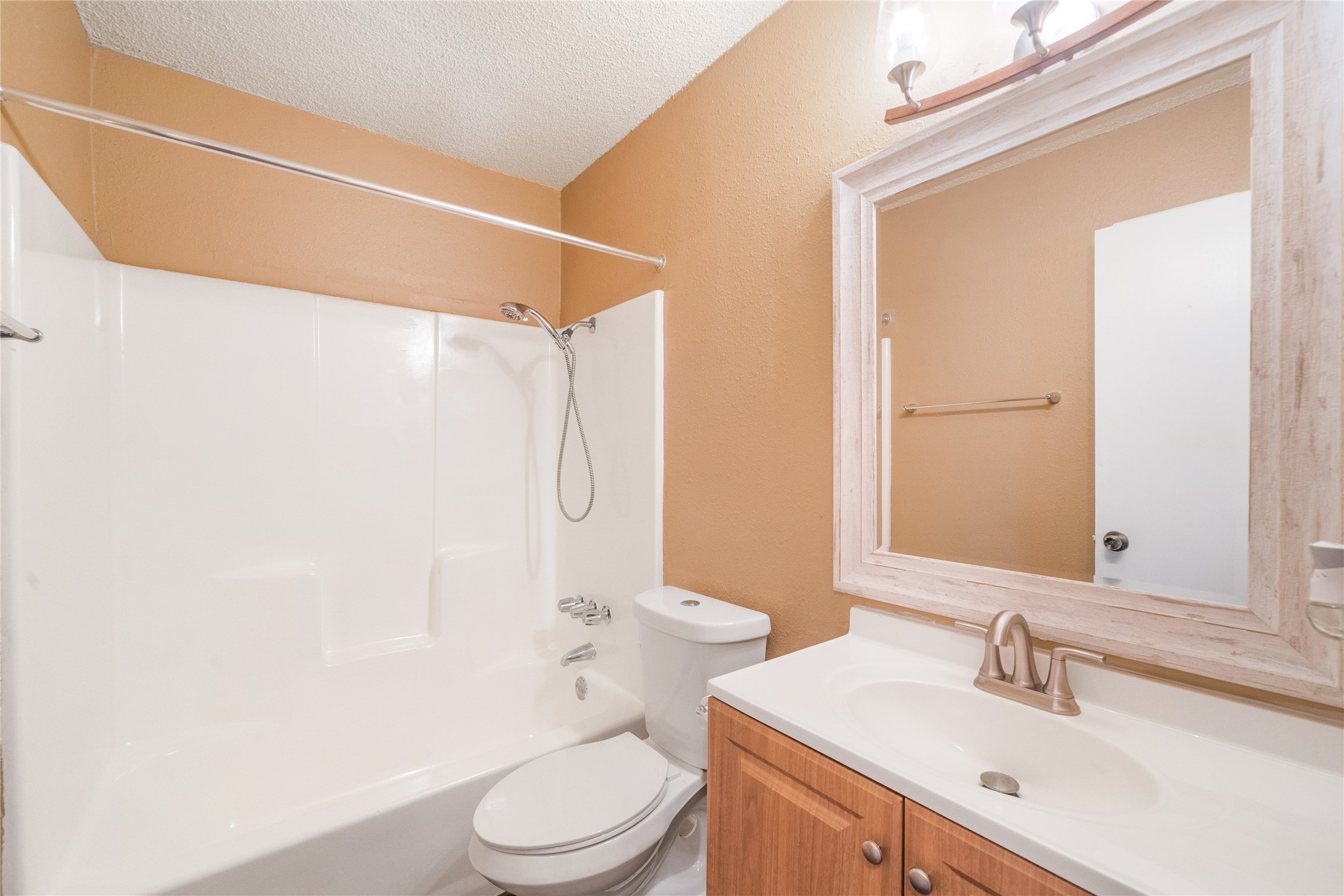 5412 Atascosa Drive, Unit B Austin, TX 78744 - Photo 8 of 15 Bathroom featuring a textured ceiling, vanity, shower / bath combination, and a textured wall