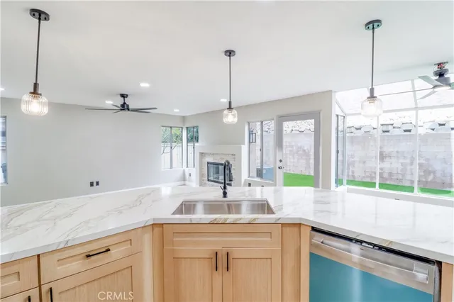 a kitchen with stainless steel appliances granite countertop a sink a counter space and a chandelier