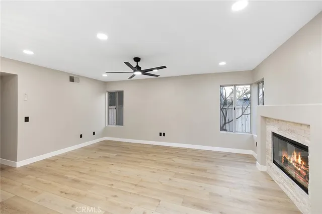 a large white kitchen with a large window and a fireplace