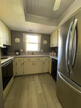 a kitchen with stainless steel appliances a sink a stove a refrigerator and cabinets