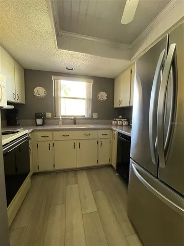 a kitchen with stainless steel appliances a sink a stove a refrigerator and cabinets