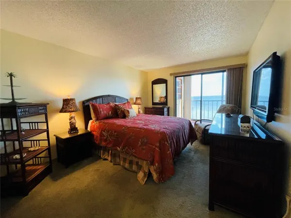 a spacious bedroom with a bed and large windows