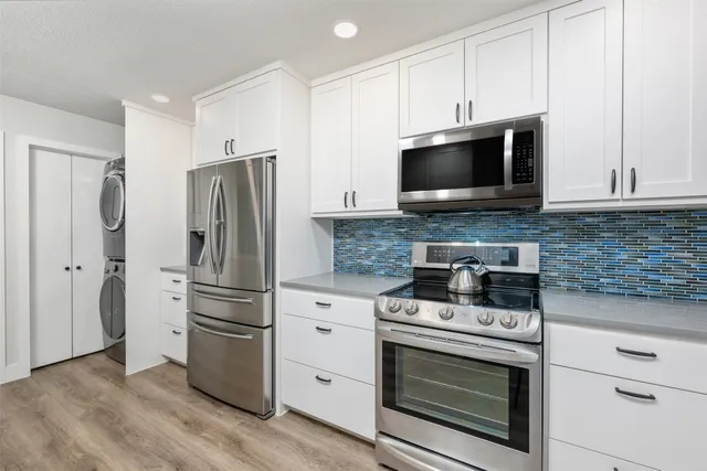 a kitchen with granite countertop a stove microwave and refrigerator