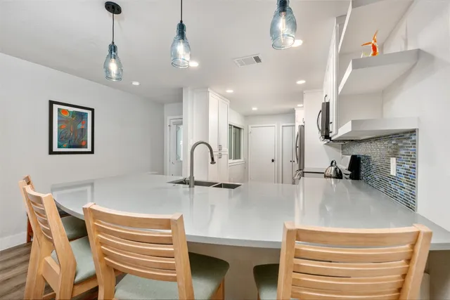 a kitchen with kitchen island a sink stainless steel appliances and cabinets