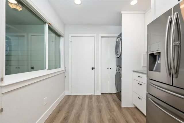 a view of kitchen with stainless steel appliances wooden floor and window