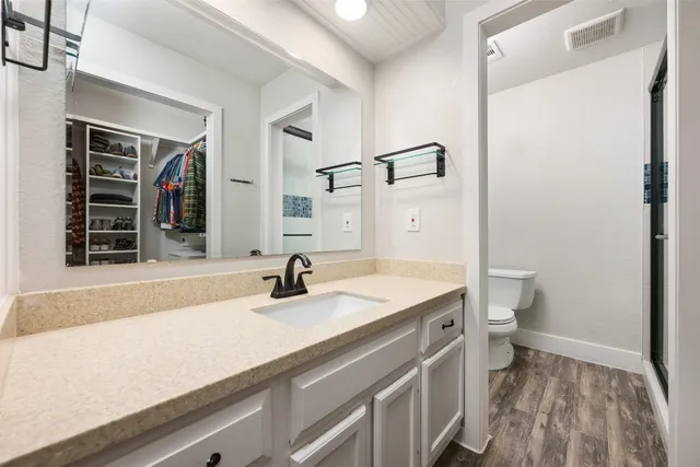 a bathroom with a sink a toilet and shower
