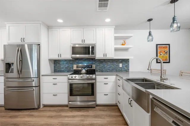 a kitchen with stainless steel appliances a stove microwave and refrigerator