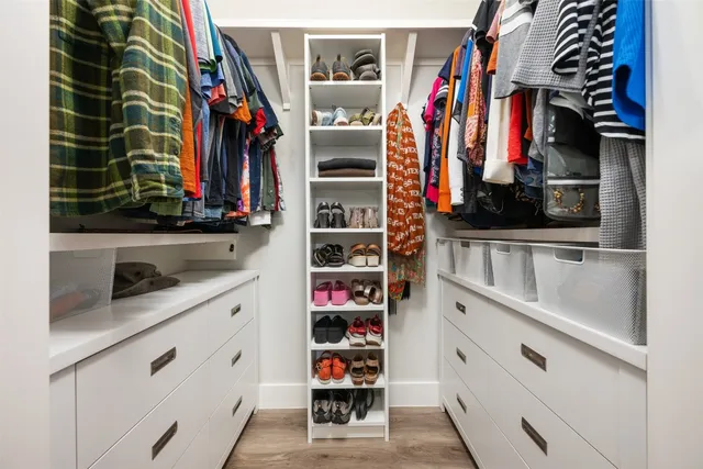a view of walk in closet with clothes and shoes