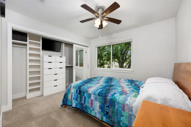 a bedroom with a bed closet and window