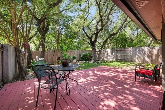 a view of a backyard with table and chairs with wooden fence and plants
